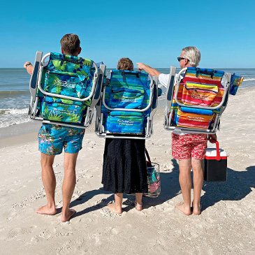 Three people carrying beach chairs